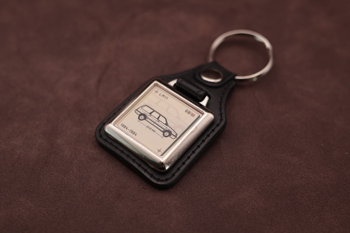 Austin Montego Estate Register Series keyring angled with the split ring at upper right and ivory vehicle artwork visible