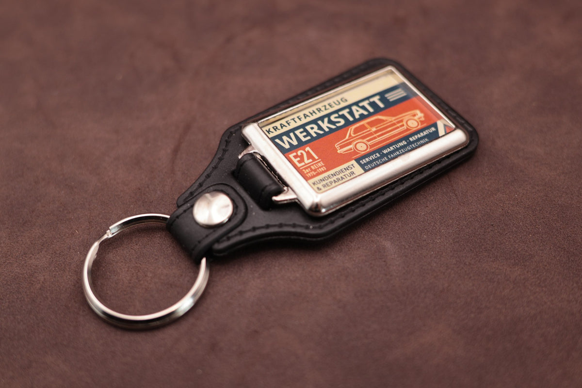BMW E21 Werkstatt keyring angled with the split ring at lower left, showing the printed label and black leatherette fob