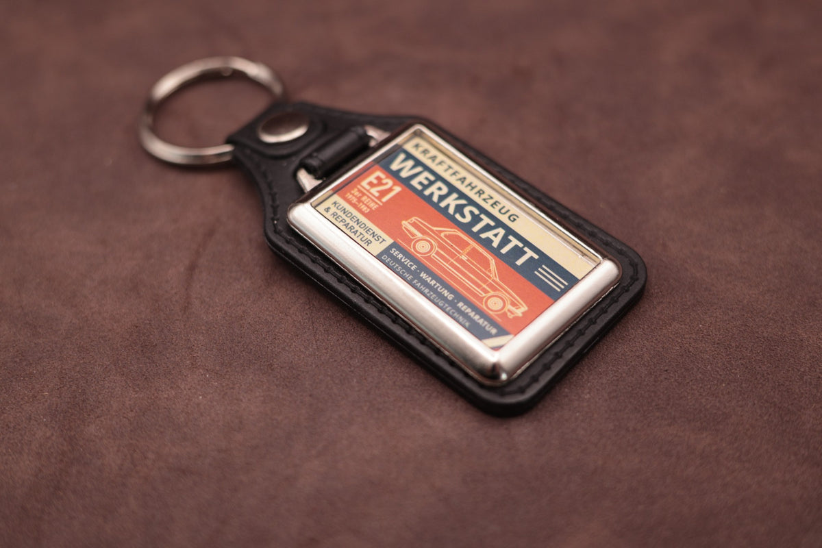 BMW E21 Werkstatt keyring angled with the split ring at upper left, showing the printed label and chromed frame