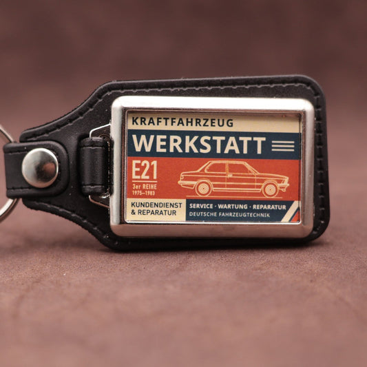 BMW E21 Werkstatt keyring with cream, dark blue and rust red workshop lettering and vehicle illustration