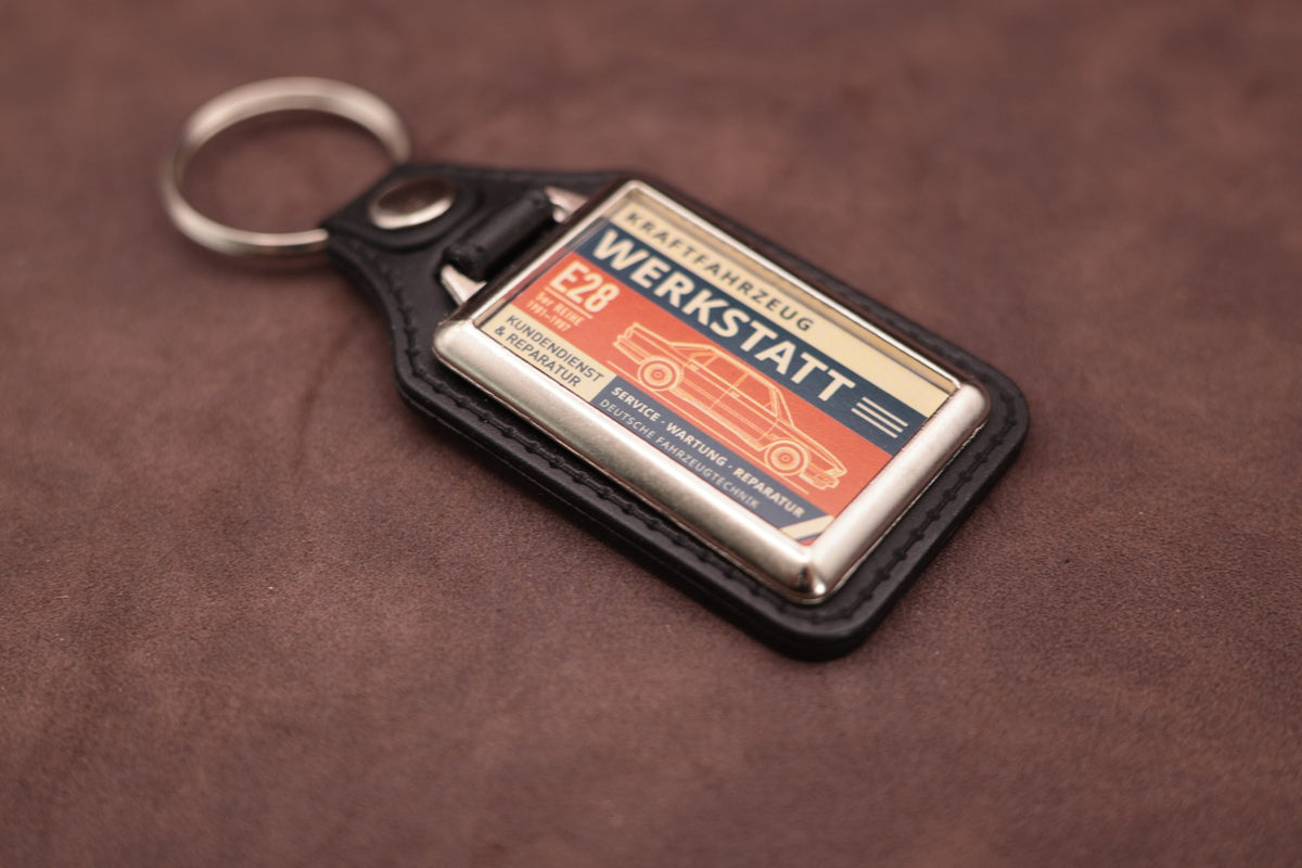 BMW E28 Werkstatt keyring angled with the split ring at upper left, showing the printed label and chromed frame