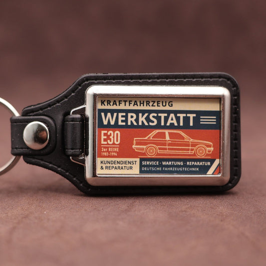 BMW E30 Werkstatt keyring with cream, dark blue and rust red workshop lettering and vehicle illustration