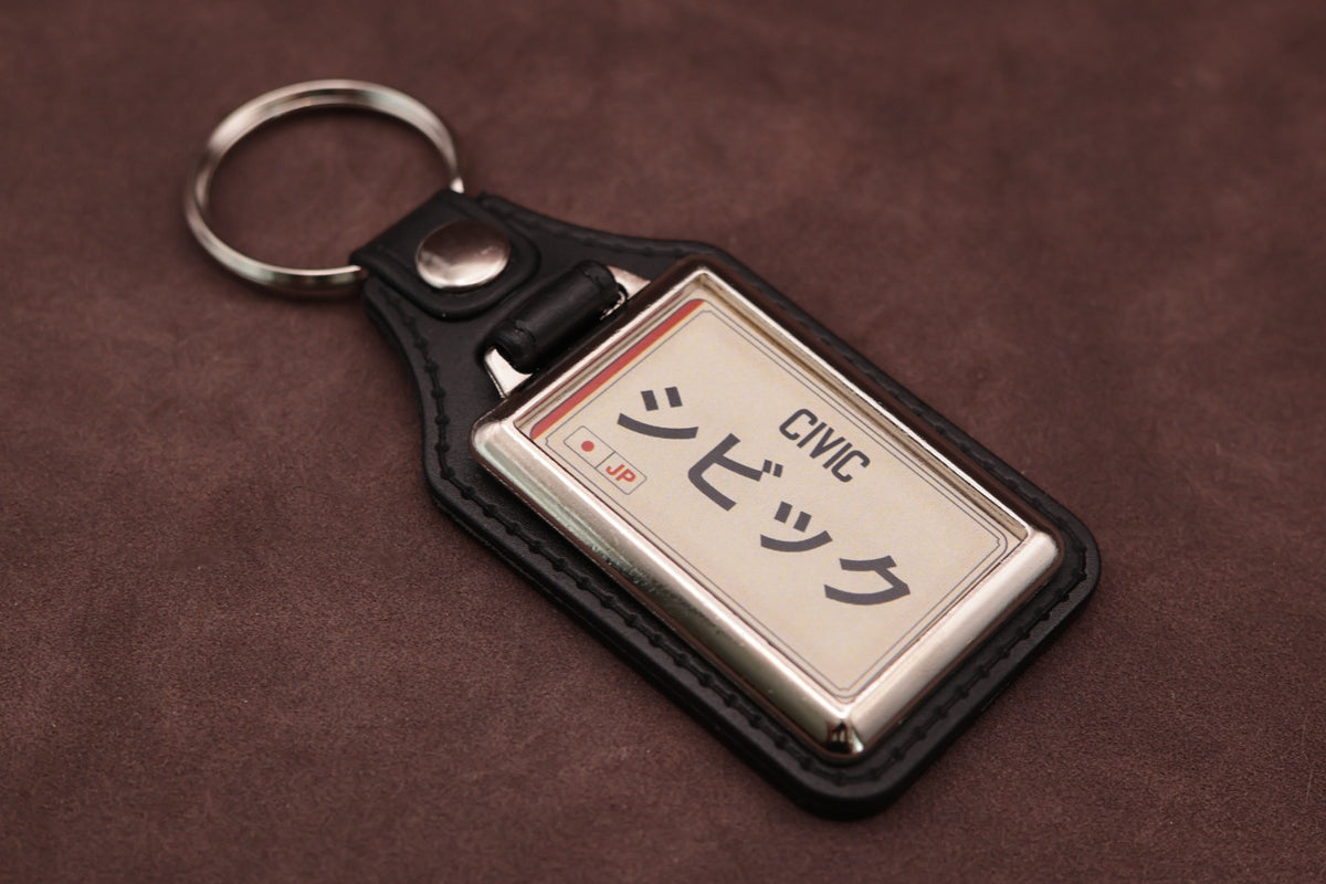 Honda Civic Katakana keyring angled with the split ring at upper left, showing the printed insert and chromed frame