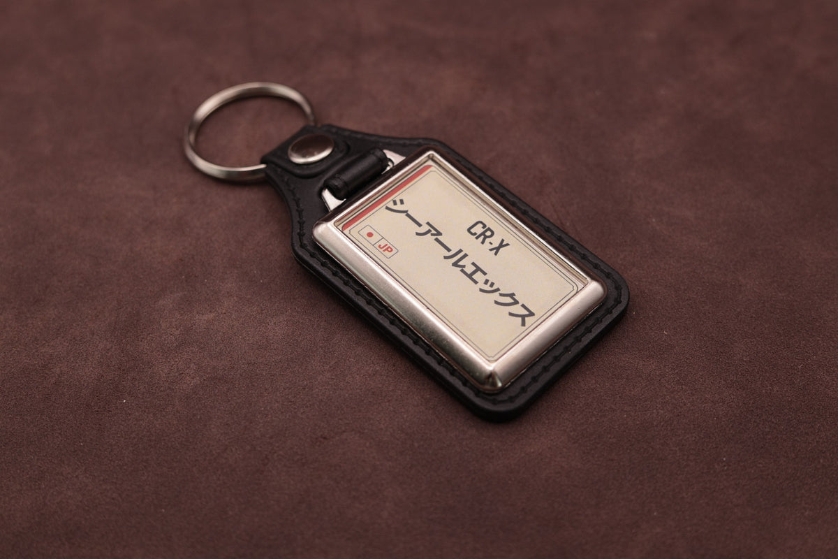 Honda CR-X Katakana keyring angled with the split ring at upper left, showing the printed insert and chromed frame