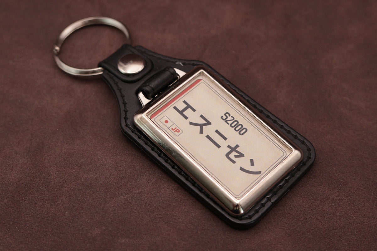 Honda S2000 Katakana keyring angled with the split ring at upper left, showing the printed insert and chromed frame