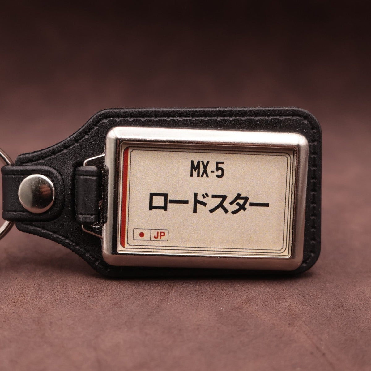 Mazda MX-5 keyring with Japanese katakana and model lettering on a cream plate-inspired insert