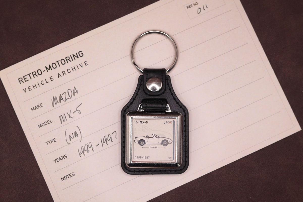Mazda MX-5 NA Register Series keyring photographed on a Retro-Motoring vehicle archive card