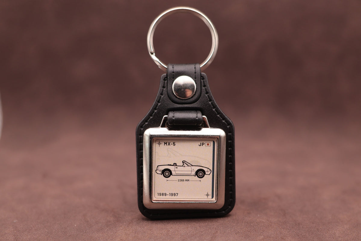 Mazda MX-5 NA Register Series keyring with ivory insert and side-profile vehicle illustration