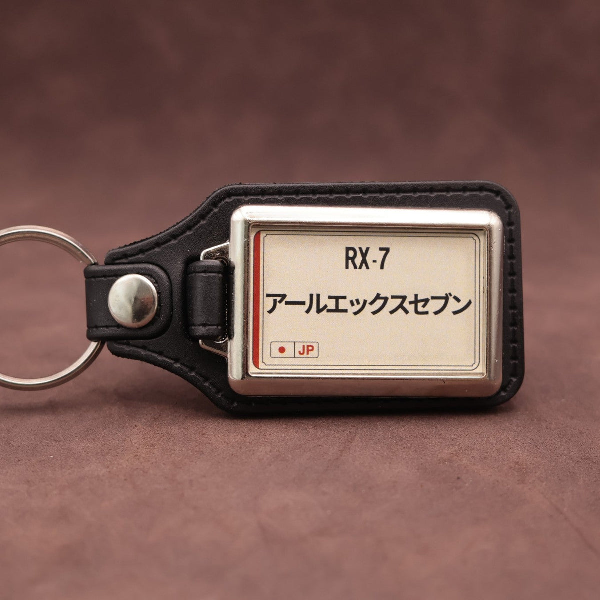 Mazda RX-7 keyring with Japanese katakana and model lettering on a cream plate-inspired insert