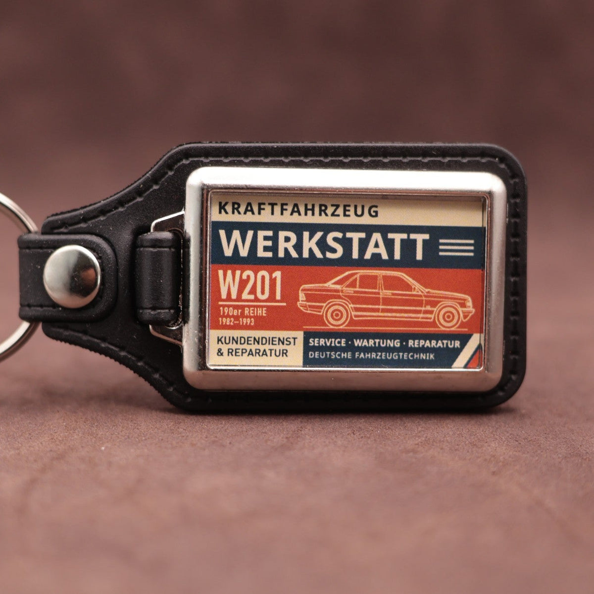 Mercedes-Benz W201 190 Werkstatt keyring with cream, dark blue and rust red workshop lettering and vehicle illustration