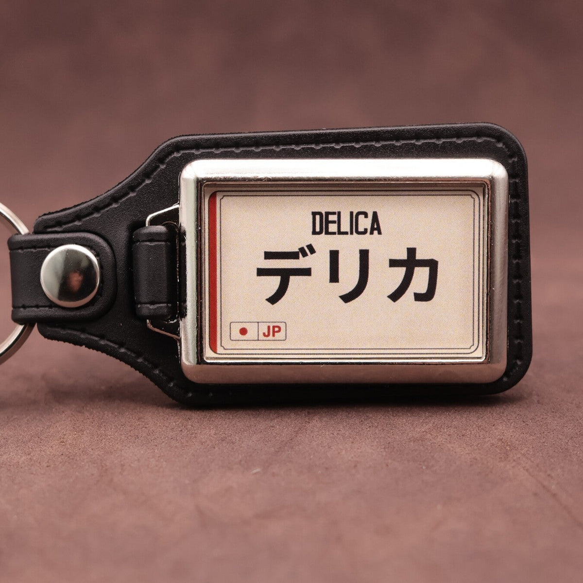 Mitsubishi Delica keyring with Japanese katakana and model lettering on a cream plate-inspired insert