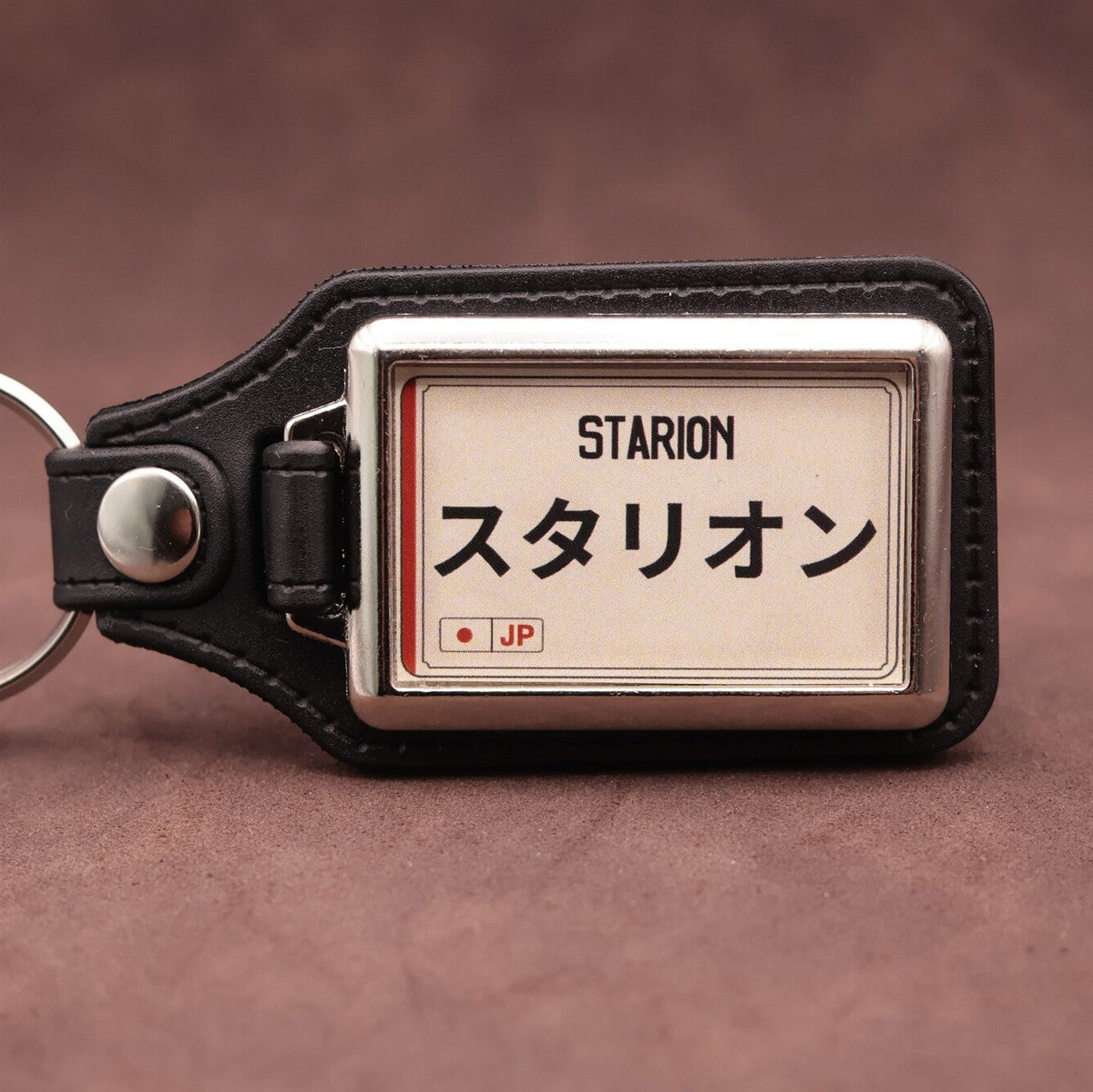 Mitsubishi Starion keyring with Japanese katakana and model lettering on a cream plate-inspired insert