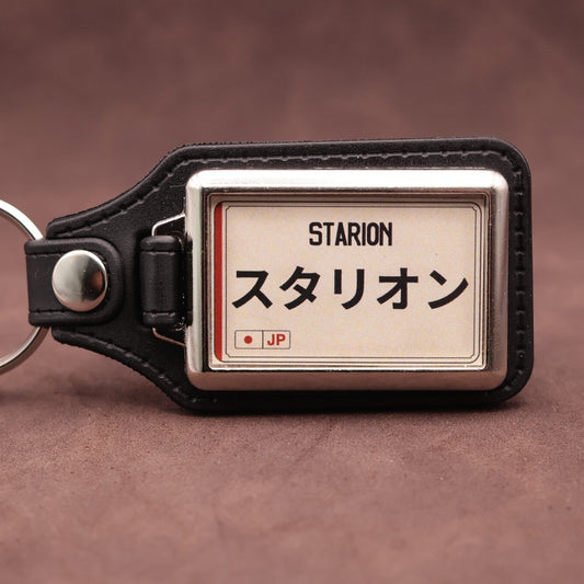 Mitsubishi Starion keyring with Japanese katakana and model lettering on a cream plate-inspired insert