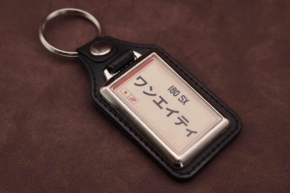 Nissan 180SX Katakana keyring angled with the split ring at upper left, showing the printed insert and chromed frame