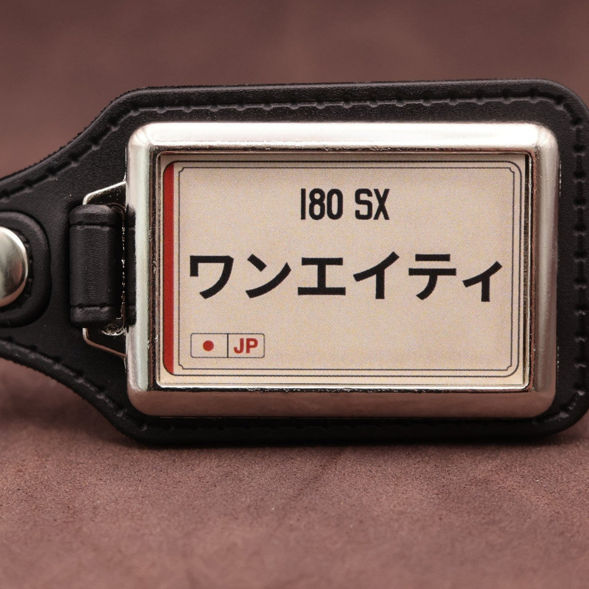 Nissan 180SX keyring with Japanese katakana and model lettering on a cream plate-inspired insert