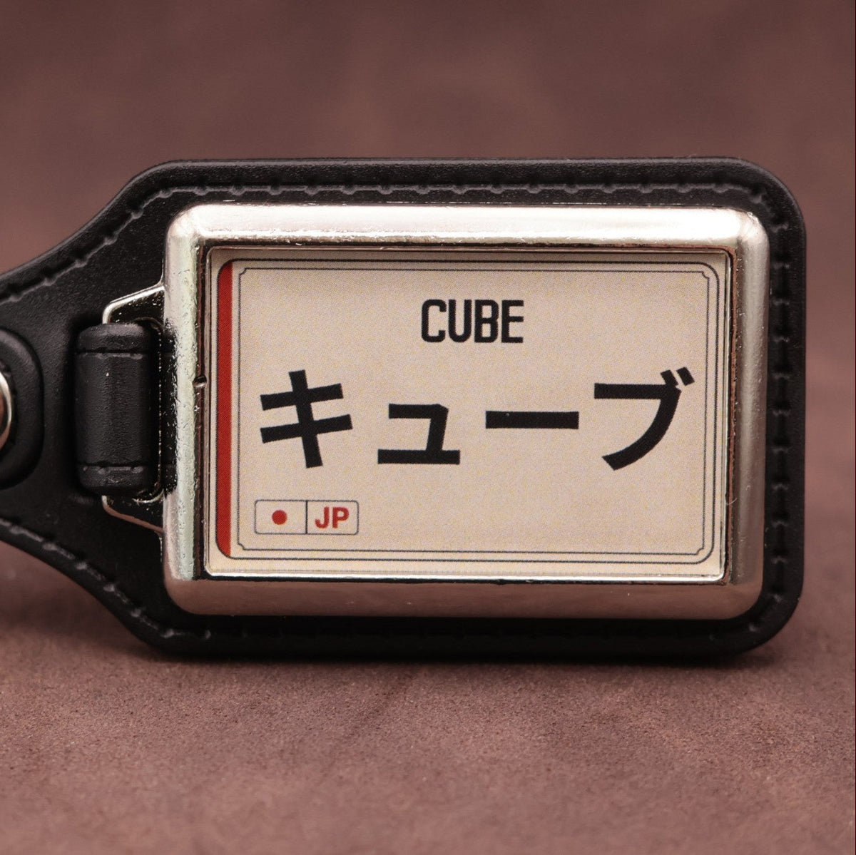 Nissan Cube keyring with Japanese katakana and model lettering on a cream plate-inspired insert