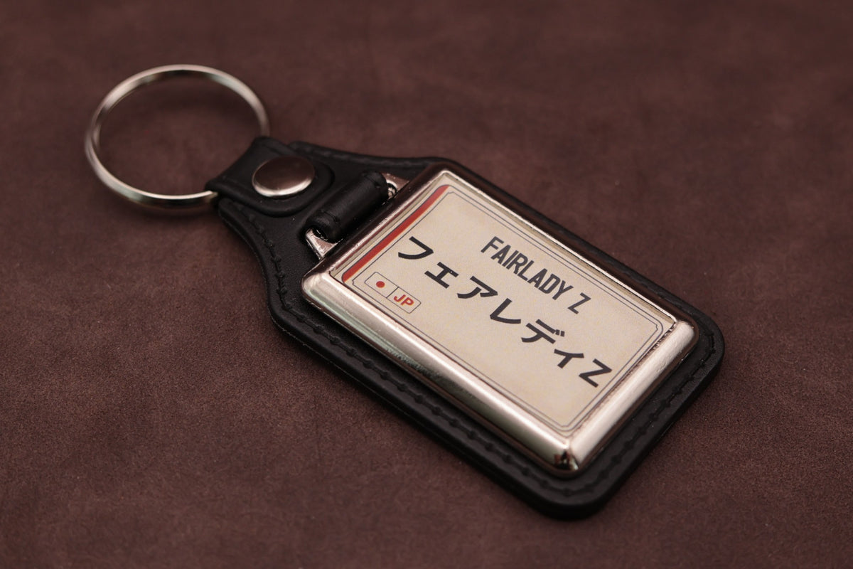 Nissan Fairlady Z Katakana keyring angled with the split ring at upper left, showing the printed insert and chromed frame