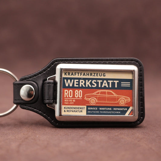 NSU Ro80 Werkstatt keyring with cream, dark blue and rust red workshop lettering and vehicle illustration
