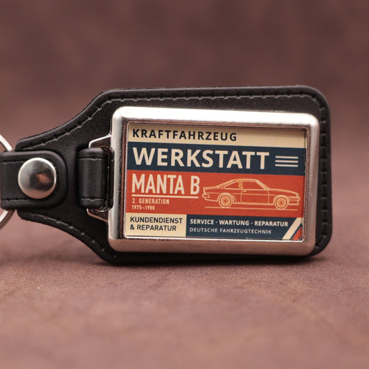 Opel Manta B Werkstatt keyring with cream, dark blue and rust red workshop lettering and vehicle illustration