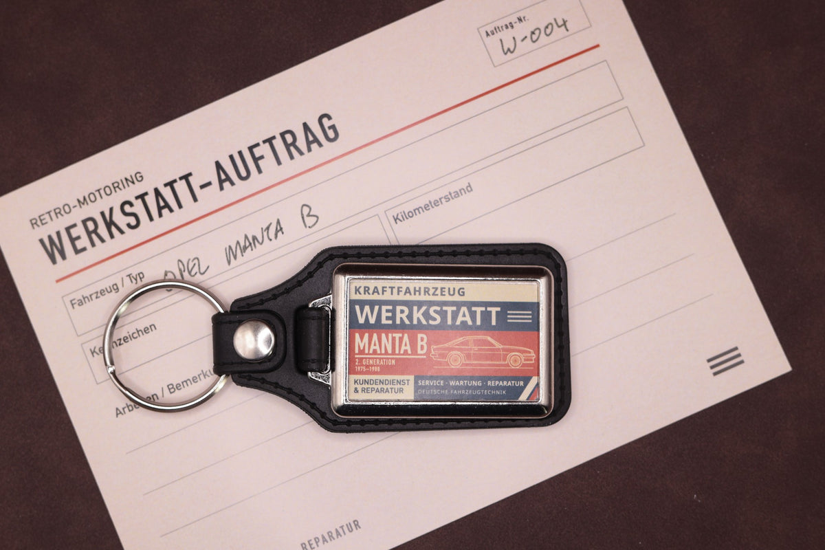 Opel Manta B Werkstatt keyring photographed with a Werkstatt reference card