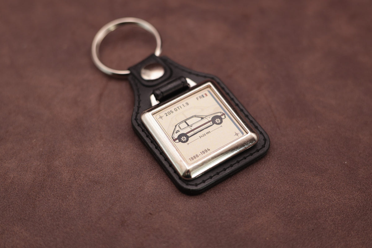 Peugeot 205 GTI 1.9 Register Series keyring angled with the split ring at upper left, showing the square chromed frame