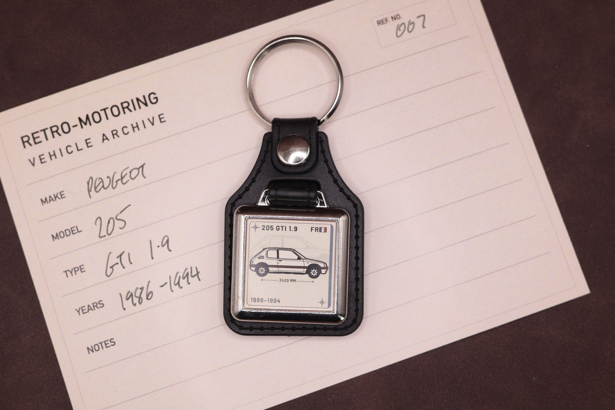 Peugeot 205 GTI 1.9 Register Series keyring photographed on a Retro-Motoring vehicle archive card