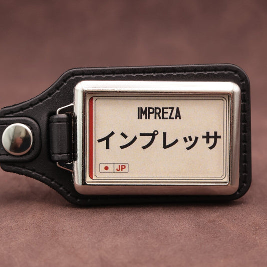 Subaru Impreza keyring with Japanese katakana and model lettering on a cream plate-inspired insert