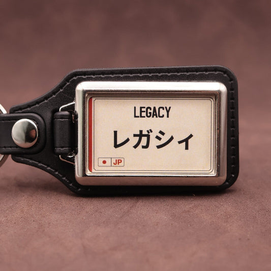 Subaru Legacy keyring with Japanese katakana and model lettering on a cream plate-inspired insert