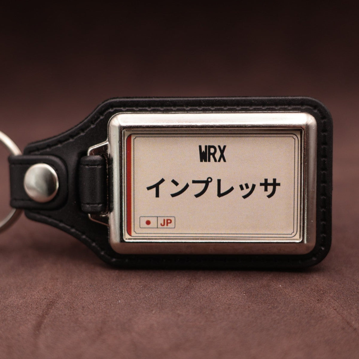 Subaru WRX keyring with Japanese katakana and model lettering on a cream plate-inspired insert
