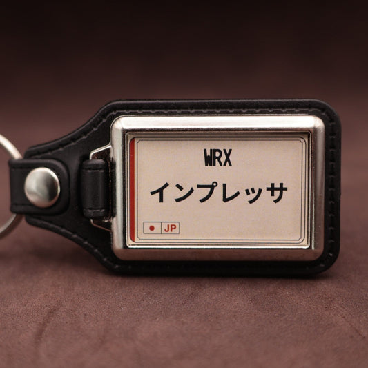 Subaru WRX keyring with Japanese katakana and model lettering on a cream plate-inspired insert