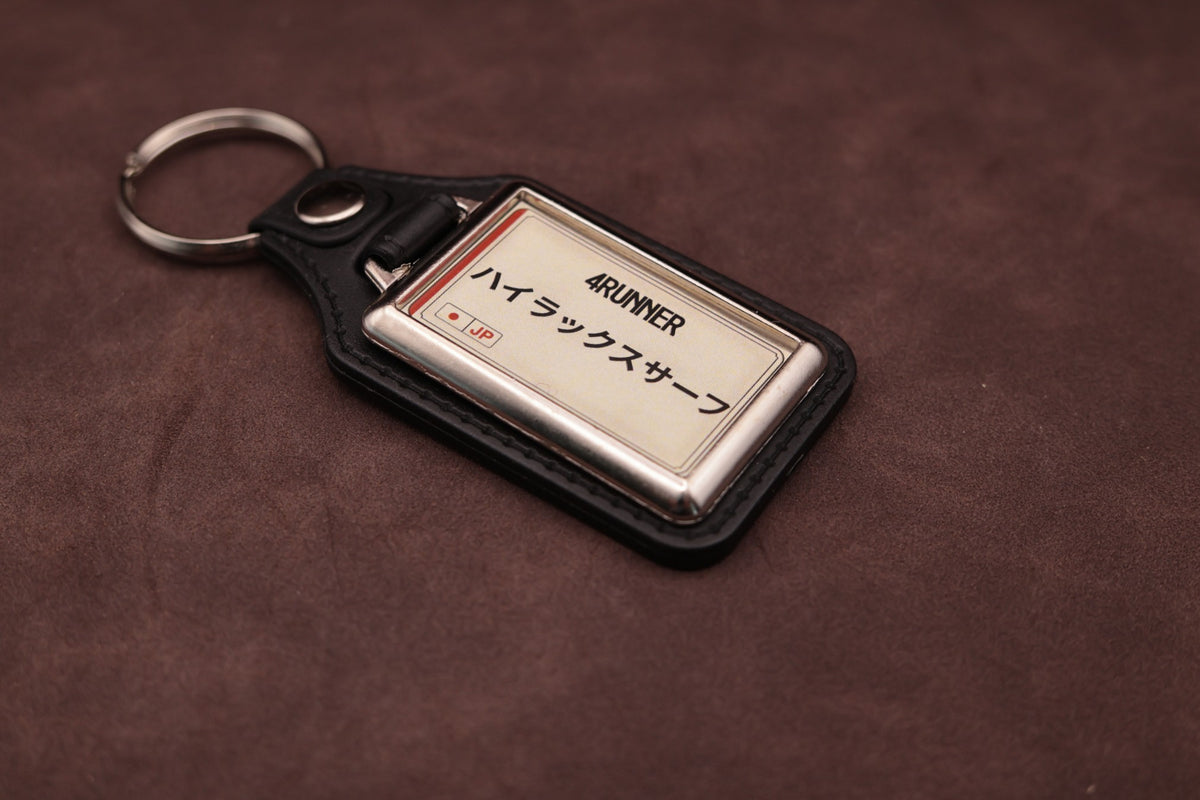 Toyota 4Runner Katakana keyring angled with the split ring at upper left, showing the printed insert and chromed frame