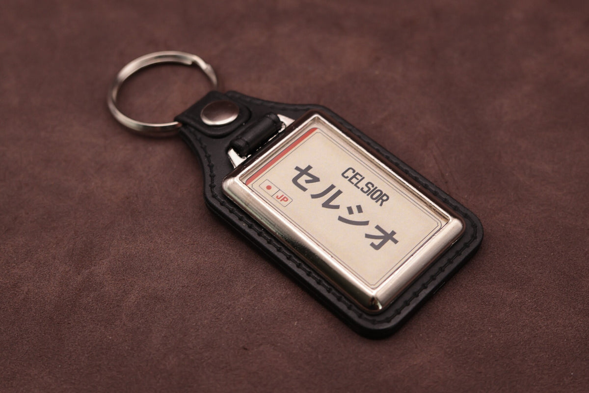 Toyota Celsior Katakana keyring angled with the split ring at upper left, showing the printed insert and chromed frame