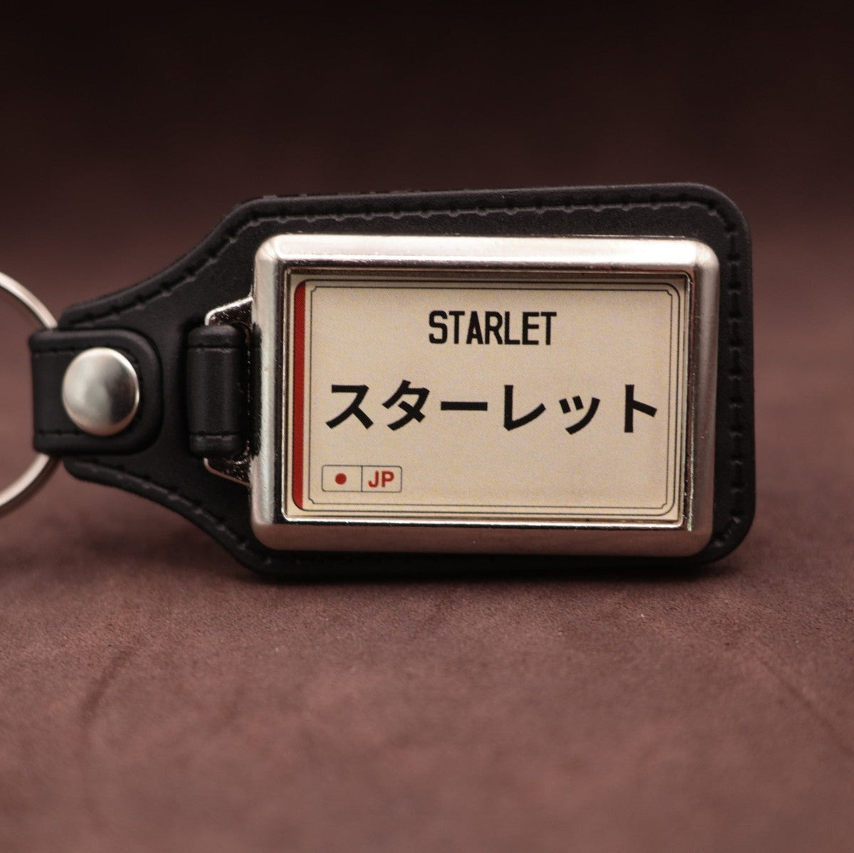 Toyota Starlet keyring with Japanese katakana and model lettering on a cream plate-inspired insert