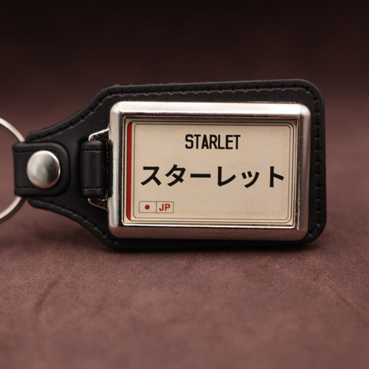 Toyota Starlet keyring with Japanese katakana and model lettering on a cream plate-inspired insert