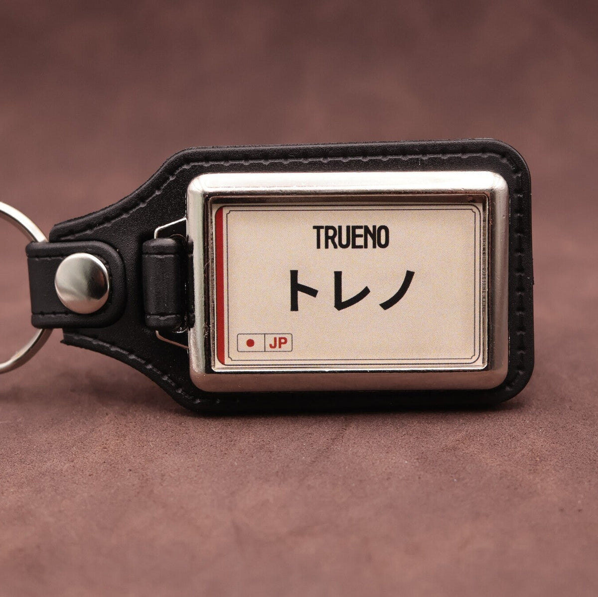 Toyota Trueno keyring with Japanese katakana and model lettering on a cream plate-inspired insert