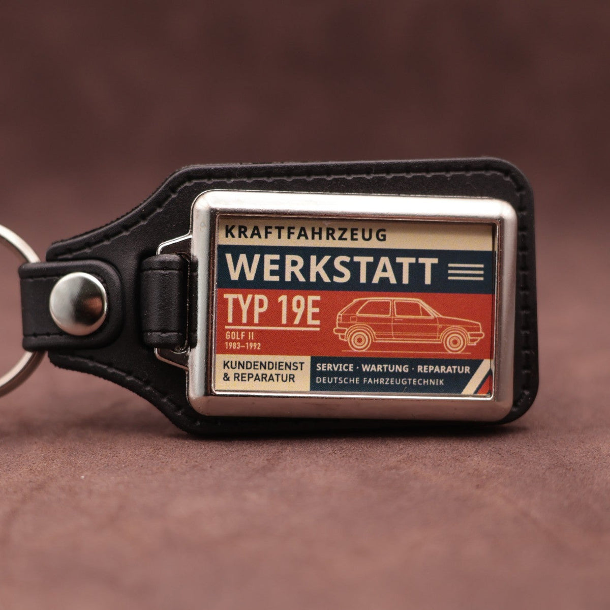 Volkswagen Golf Mk2 Werkstatt keyring with cream, dark blue and rust red workshop lettering and vehicle illustration