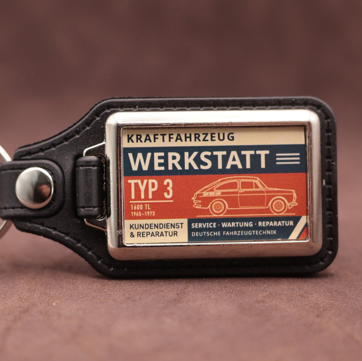 Volkswagen Type 3 Fastback Werkstatt keyring with cream, dark blue and rust red workshop lettering and vehicle illustration